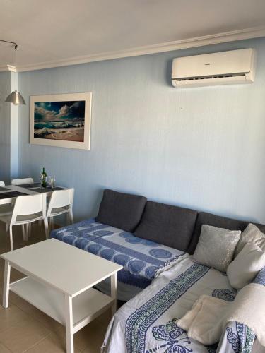uma sala de estar com um sofá e uma mesa em Apartament Jardin De Alba in Villamartin em Orihuela