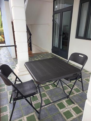 a picnic table and two chairs on a porch at Boisbleu villa in Flic-en-Flac