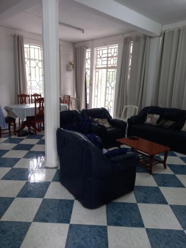 a living room with couches and a checkered floor at Boisbleu villa in Flic-en-Flac