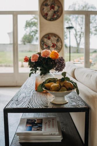 a table with a bowl of food and flowers on it at Les Granges Pelloquin in Bernières-sur-Mer