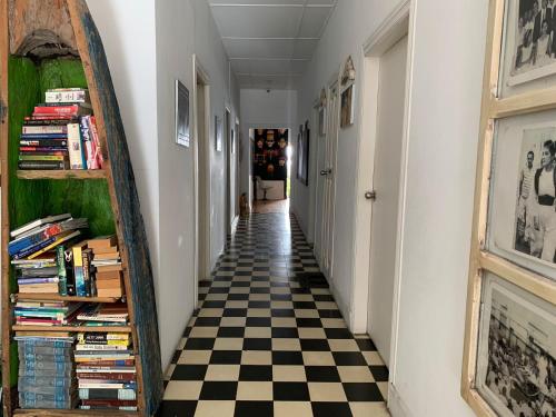 a hallway with a checkerboard floor and a mirror at Hostel Mamy Dorme in Barranquilla