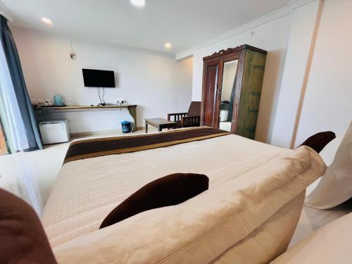 una camera con un grande letto e una televisione di Nagas Hotel Satyavati Morjim a Morjim