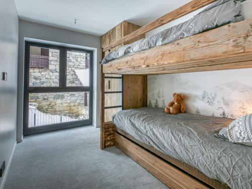 a teddy bear sitting on a bed in a bedroom at Appartement Val-d'Isère, 3 pièces, 5 personnes - FR-1-694-338 in Val-d'Isère
