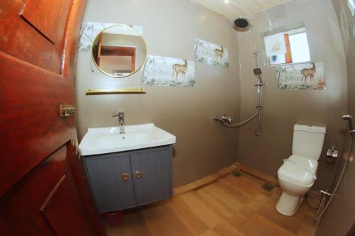 y baño con lavabo, aseo y espejo. en Heavenly Home Inn, en Nuwara Eliya