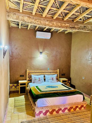 a bedroom with a bed in a room at Camping auberge palmeraie d'amezrou in Zagora