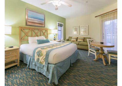 a bedroom with a bed and a couch and a table at Myrtle Beach Bike Week - Spring Rally - Deluxe Studio Villa Retreat Resort - Special Offer Now! in Myrtle Beach