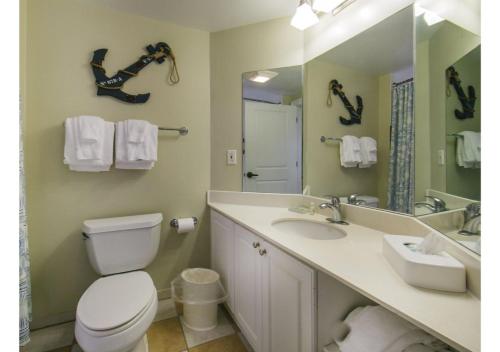 a bathroom with a toilet and a sink and a mirror at Myrtle Beach Bike Week - Spring Rally - Deluxe Studio Villa Retreat Resort - Special Offer Now! in Myrtle Beach