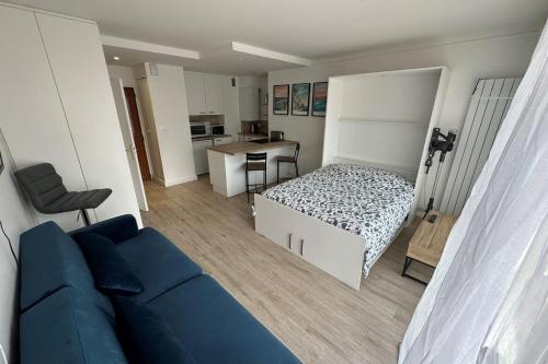 - un salon avec un canapé bleu et un lit dans l'établissement Perfect studio for a romantic getaway, à La Baule
