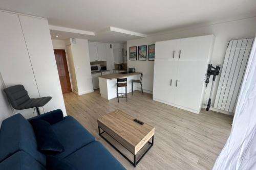 un salon avec un canapé bleu et une table dans l'établissement Perfect studio for a romantic getaway, à La Baule