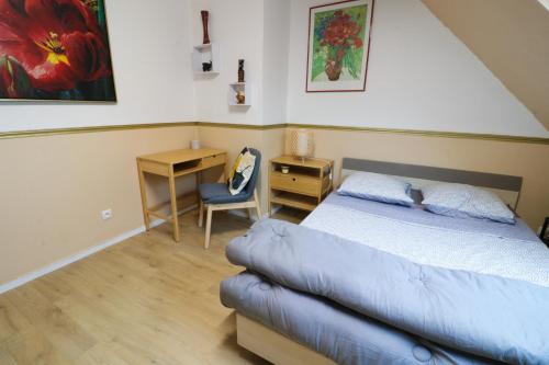 1 dormitorio con cama, escritorio y silla en Nov Sweety Home en Goussainville