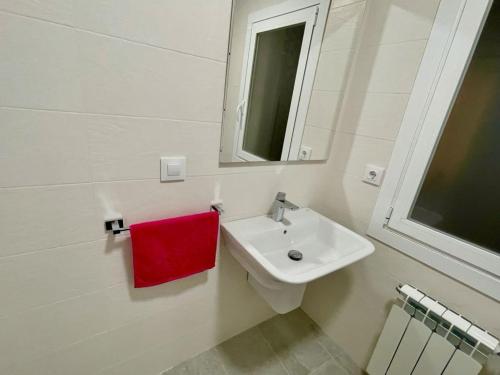 baño con lavabo blanco y toalla roja en PRECIOSO PISO CENTRO, en Ourense