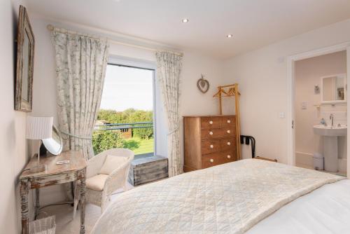 a bedroom with a bed and a window and a chair at Spreacombe Lodge in Woolacombe