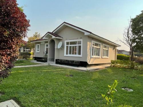 a small house in a yard with green grass at Silverest Sanctuary: Home away from Home in Lusaka