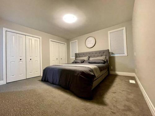 a bedroom with a bed with a clock on the wall at Hillside Villa - Trenton in Trenton