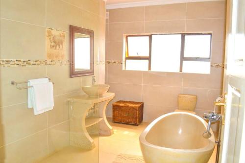 uma casa de banho com uma banheira, um lavatório e um WC. em Mt Pleasant - 4-Bed Villa in Harare Solar Power em Kingsmead