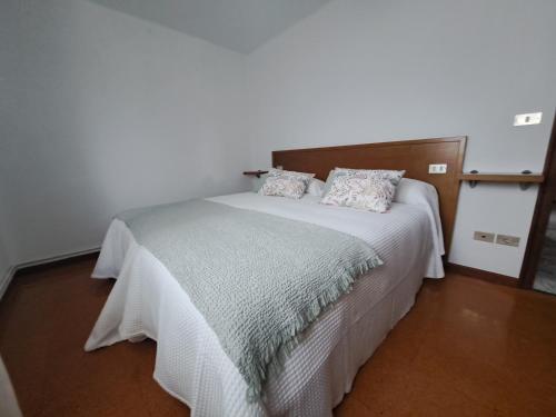 ein Schlafzimmer mit einem weißen Bett mit Kissen darauf in der Unterkunft A Reitoral in Vigo