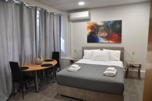 una camera con un letto, un tavolo e un quadro di Athens Panormou Central Apartment Zeus by SuperHost Hub ad Atene