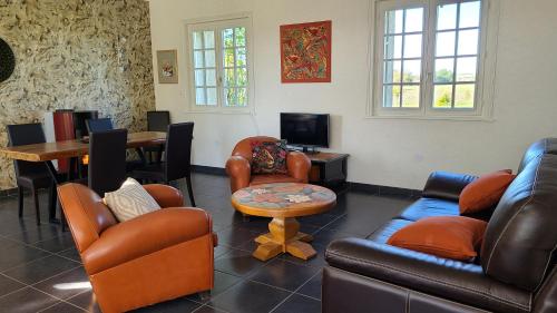 uma sala de estar com mobiliário de couro e uma mesa em Chambres d'hôtes Domaine des Formes em Effiat