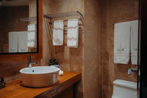 a bathroom with a sink and a toilet and a mirror at The Bannister Hotel & Yacht Club by Mint in Santa Bárbara de Samaná