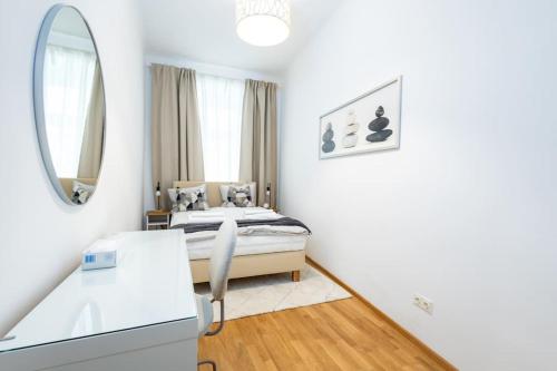 Schlafzimmer mit einem Bett und einem Spiegel in der Unterkunft OrestaLiving - Danube Canal in Wien