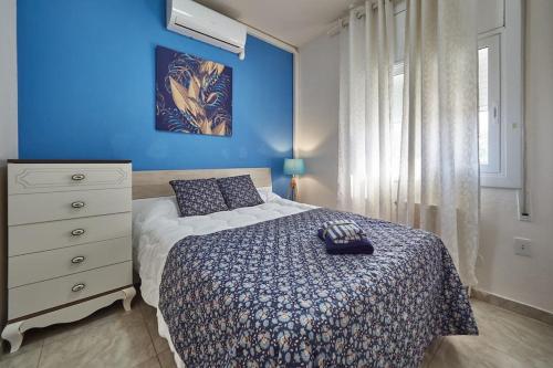 a bedroom with a bed and a blue wall at Villa Soledad en Olivella, Sitges, Barcelona in Olivella
