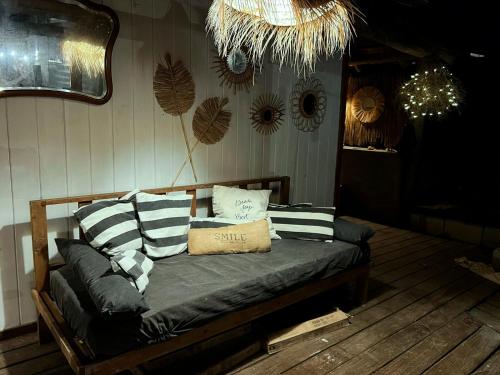 a bed with pillows on it in a room at Pueblo Arriba Hostel in Punta Del Diablo