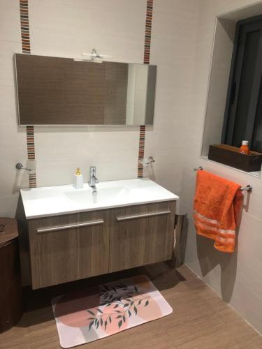 a bathroom with a sink and an orange towel at Room in Trilithon Court Apartments Ghaxaq in Hal Ghaxiak