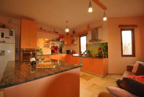 cocina con armarios de color naranja y encimera en Pink Garden Events Advance Notice Required, en Giarmata