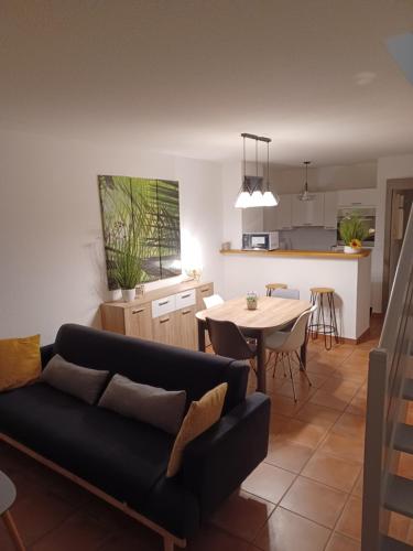 un salon et une cuisine avec un canapé et une table dans l'établissement Charmante villa dans village naturiste, à Leucate