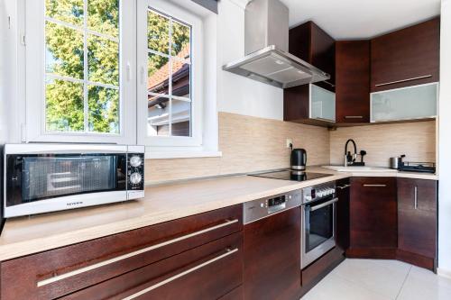 a kitchen with wooden cabinets and a microwave at Chill Warmia in Dywity