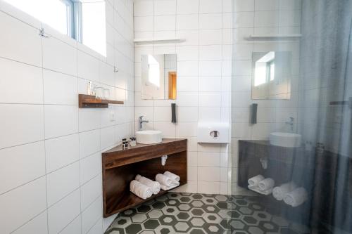 a white bathroom with a sink and a mirror at Hótel Skógafoss by EJ Hotels in Skogar