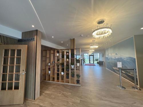 a large lobby with a chandelier and a room with a hallway at Hótel Skógafoss by EJ Hotels in Skogar