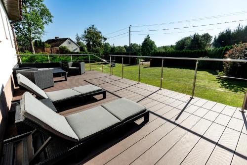 a patio with two chairs and a couch on a deck at Chill Warmia in Dywity