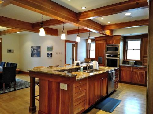 a large kitchen with wooden cabinets and a large island at Beautiful 1910 American Craftsman home, close to Bozeman Hot Springs, near Bozeman and Big Sky, Montana. in Gallatin Gateway