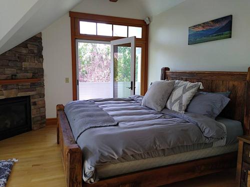 a large bed in a room with a fireplace at Beautiful 1910 American Craftsman home, close to Bozeman Hot Springs, near Bozeman and Big Sky, Montana. in Gallatin Gateway