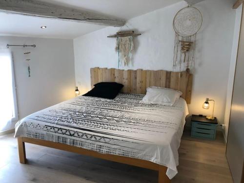 ル・ボーセにあるKembali mini loftのベッドルーム1室(大型ベッド1台、木製ヘッドボード付)