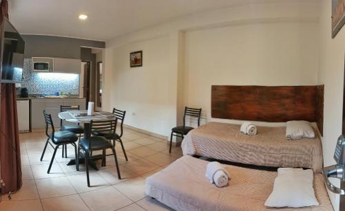 um quarto com 2 camas, uma mesa e uma cozinha em Puna II - Depto p/4 con estacionamiento em Salta