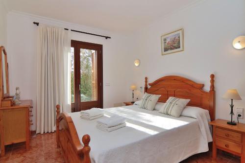 una camera da letto con un grande letto bianco e una finestra di Finca Son Tresco 126 by Mallorca Charme a Búger