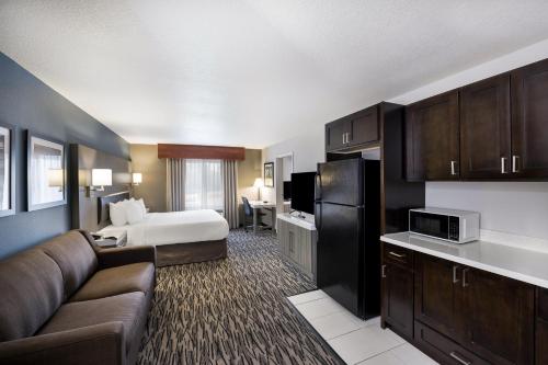 a hotel room with a bed and a couch at Best Western PLUS Mountain View Auburn Inn in Auburn