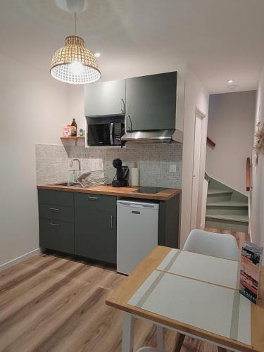 une cuisine avec une table et un comptoir dans l'établissement T2 cozy proche centre, à Bergerac