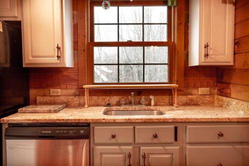 uma cozinha com um lavatório e uma janela em O'Harrah's Hundred em Grantsville