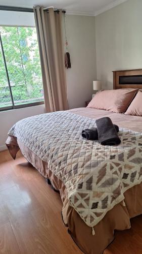 a bedroom with a bed with a blanket on it at Full departamento, Metro Manquehue, Las Condes in Santiago