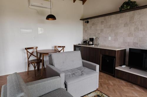 a living room with a couch and a table and a tv at Cabanas Vinsanto in Bento Gonçalves