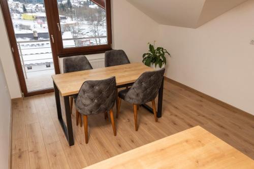 a dining room table with four chairs and a plant at Apartment Marija in Pale