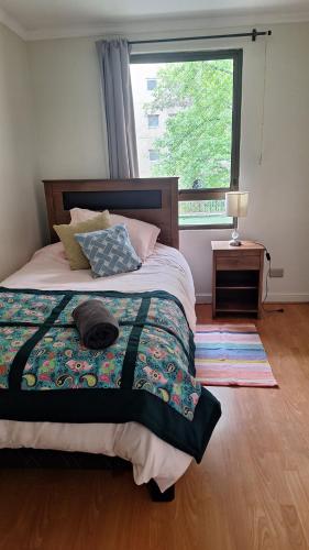 a bedroom with a bed with a large window at Full departamento, Metro Manquehue, Las Condes in Santiago