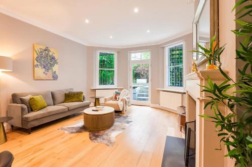 a living room with a couch and a table at Primrose Park in London