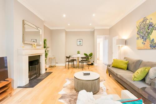 a living room with a couch and a fireplace at Primrose Park in London
