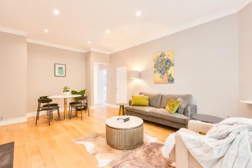 a living room with a couch and a table at Primrose Park in London
