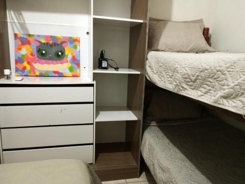 ein Schlafzimmer mit einem Bett und einem Katzengemälde in der Unterkunft Casa B com Piscina Enseada Ubatuba Max06 Hosp in São Francisco do Sul