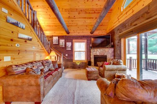una sala de estar con sofás y una chimenea en una cabaña de madera. en Pet-Friendly Garrison Retreat with Gas Fireplace!, en Garrison